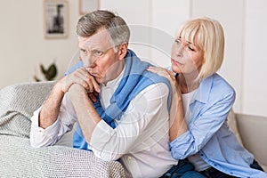 Senior woman consoling husband after arguing at home