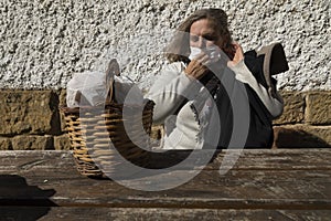 A senior woman, correctly adjusts her protective face mask