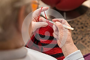 Senior woman with a crochet needle and wool