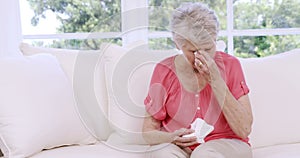 Senior woman crying on the sofa