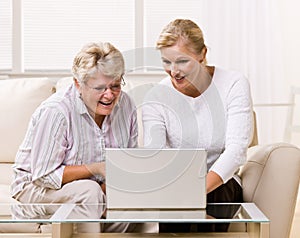 Senior woman and daughter using laptop