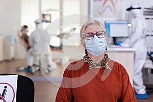 Senior woman in dental clinic wearing face mask