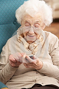 Senior Woman Dialling Number On Mobile Phone