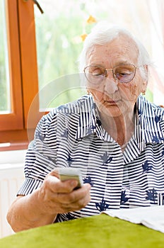 Senior Woman Dialling Number On Mobile Phone