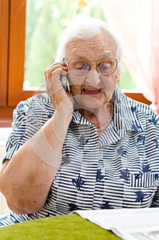 Senior Woman Dialling Number On Mobile Phone photo