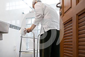 Senior woman with diarrhea holding tissue roll near a toilet bowl,elderly have abdominal pain,stomach ache,constipation,sick