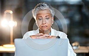 Senior woman, doctor and laptop at night thinking for healthcare solution, idea or strategy at hospital. Elderly female