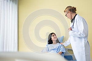 Senior Woman Doctor reassuring Asian Female patient