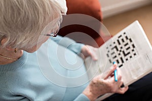 Senior Woman Doing Crossword Puzzle At Home photo