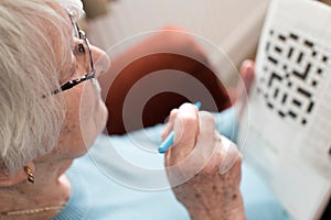 Senior Woman Doing Crossword Puzzle At Home photo
