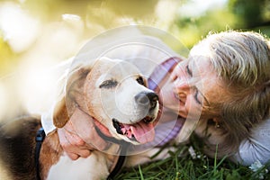 Senior woman with dog in spring nature, resting.