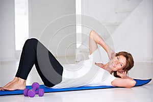 Senior woman doing curl-ups photo