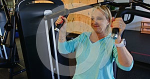 Senior woman doing exercise on chest press machine 4k