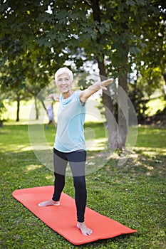 Senior woman doing exercise in the green park