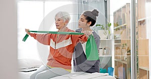 Senior woman doing a exercise with a resistance band for physiotherapy with a nurse in clinic. Fitness, healthcare and