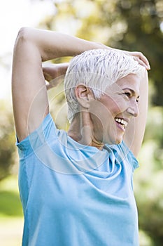 Senior woman doing exercise for stretching hand in the park
