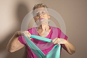 Senior woman doing rehabilitation exercises with elastic band