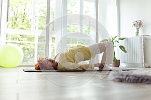 Senior woman doing shoulder supported bridge exercise