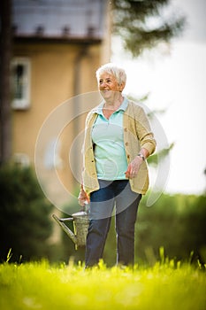 Senior woman doing some gardening in her lovely garden