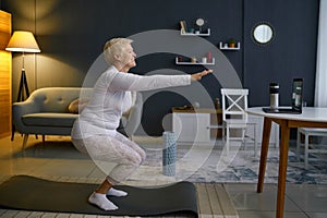 Senior woman doing squats exercising at home