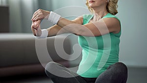 Senior woman doing stretching exercise at home, active lifestyle, health care