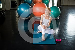 Senior woman Doing yoga in fitness gym. aged lady exercising.  Old female taking a break from  workout .Mature sport training.