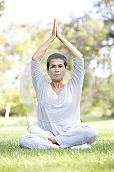 Senior Woman Doing Yoga In Park