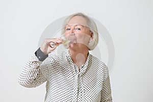 Senior woman drinking champagne