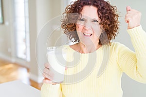 Senior woman drinking a glass of fresh milk annoyed and frustrated shouting with anger, crazy and yelling with raised hand, anger