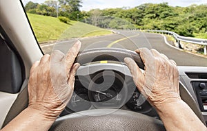 Senior woman driving a car on highway
