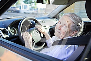 Senior woman driving car on sunny day