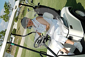 Senior woman driving golf cart