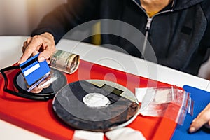 Senior woman drug addict making cocaine line with credit card on glass surface