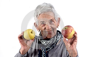 Senior woman eating apple on white