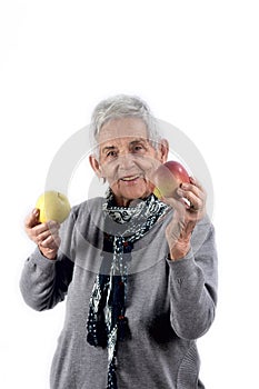 Senior woman eating apple on white