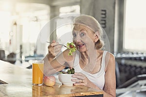 Senior woman eating healthy salad and orange juice. elderly health lifestyle nutrition concept