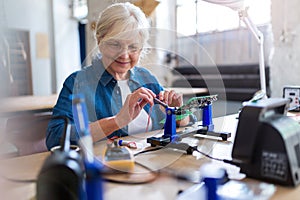 Senior woman in electronics workshop