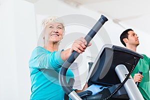 Senior woman on elliptical trainer exercising photo