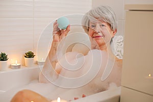 Senior woman enjoying a blue bath bomb