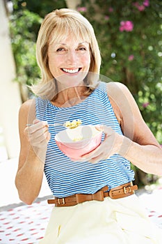 Senior Woman Enjoying Bowl Of Breakfast Cereal