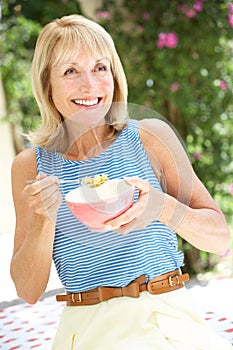 Senior Woman Enjoying Bowl Of Breakfast Cereal