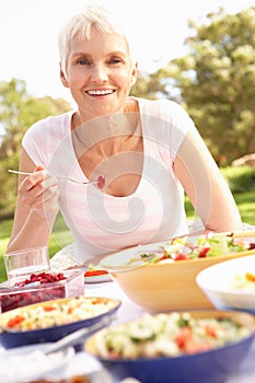 Senior Woman Enjoying Meal In Garden