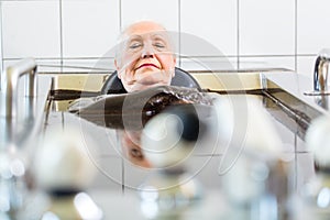 Senior woman enjoying mud bath alternative therapy