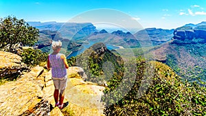 Senior woman enjoying the view of the Blyde River Canyon and Blyde River Dam, from the viewpoint at the Three Rondavels