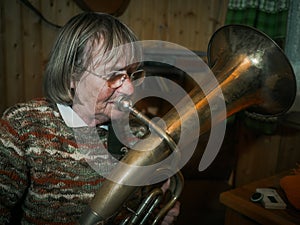 Senior woman is playing on a horn