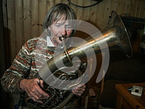 Senior woman is playing on a horn