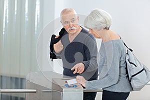 Senior woman entering card into turnstile