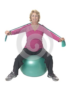 Senior woman on exercise ball with resistance band