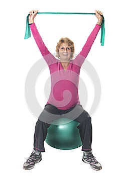 Senior woman exercising with ball and band