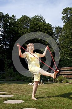 Senior woman exercising in the garden